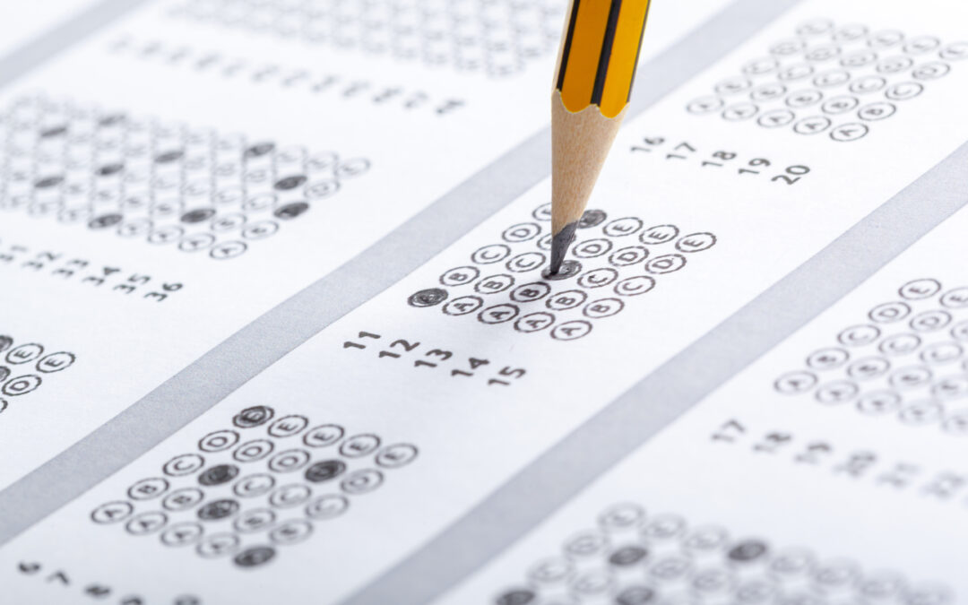 Un prim-plan al unui creion care completează o bulă de răspuns pe o foaie de răspuns la un test standardizat cu opțiuni multiple, cu instrucțiuni scrise în limba română.